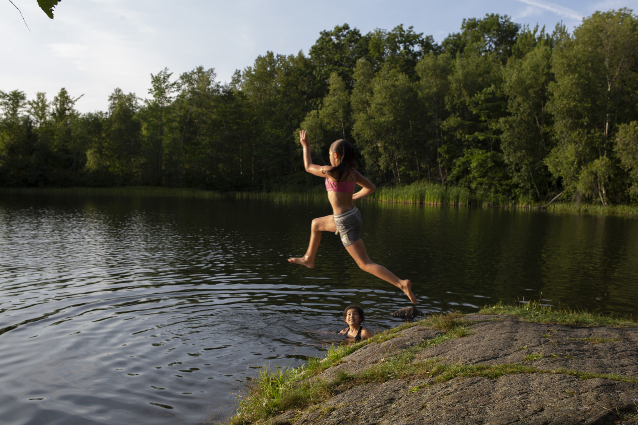 Seeing Maine - child running and jumping off rock into a lake
