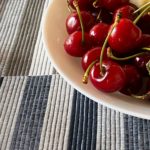 Bowl of red cherries on a striped table