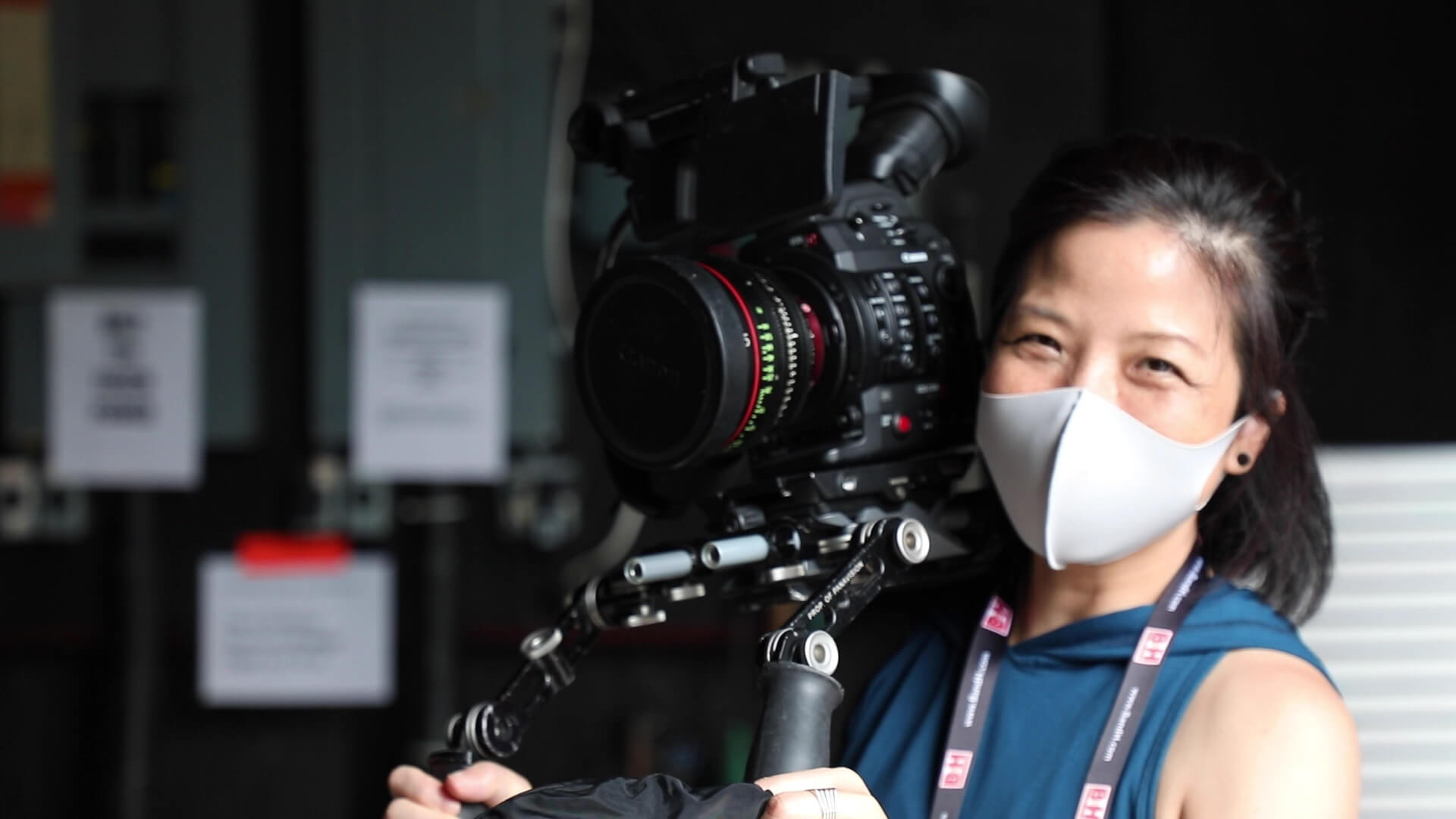 Filmmaker holding camera with mask on