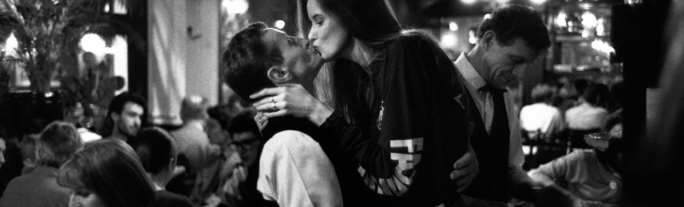 Woman kissing a man in a Parisian restaurant